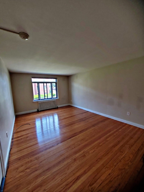 8 Ashland Street, Unit 1L Worcester, MA 01609 - Photo 5 of 27 a view of empty room with wooden floor and fan