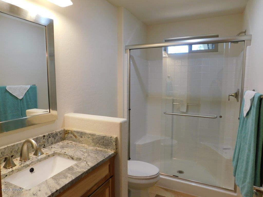 1941 Rim View Lane Heber, AZ 85928 - Photo 30 of 41 a bathroom with a granite countertop sink toilet and shower