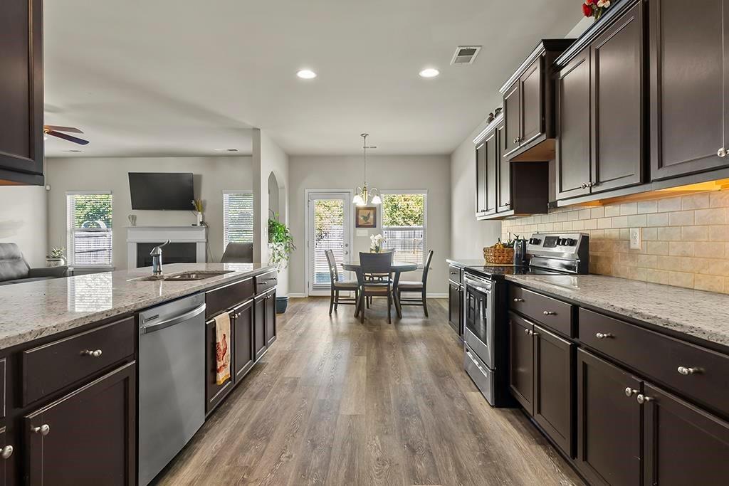 184 Amelia Drive Byron, GA 31008 - Photo 11 of 43 a kitchen with stainless steel appliances granite countertop sink stove top oven and cabinets