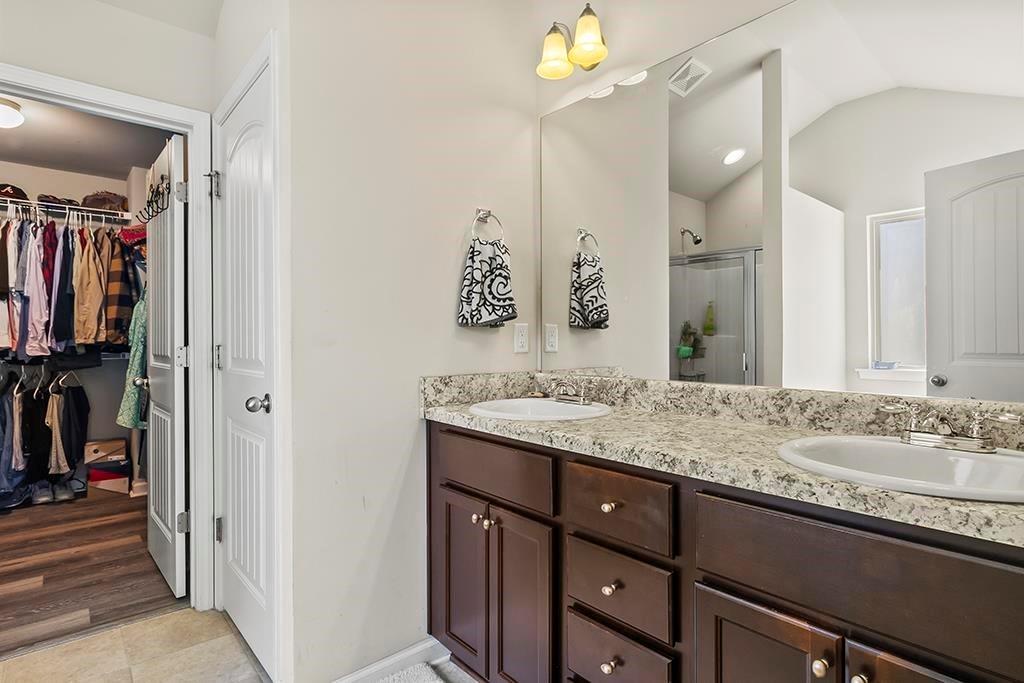 184 Amelia Drive Byron, GA 31008 - Photo 16 of 43 a bathroom with a granite countertop sink a mirror and a shower