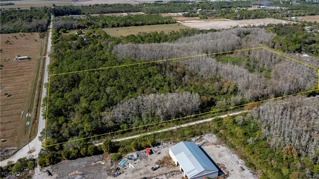 an aerial view of ocean with residential house with outdoor space and trees around