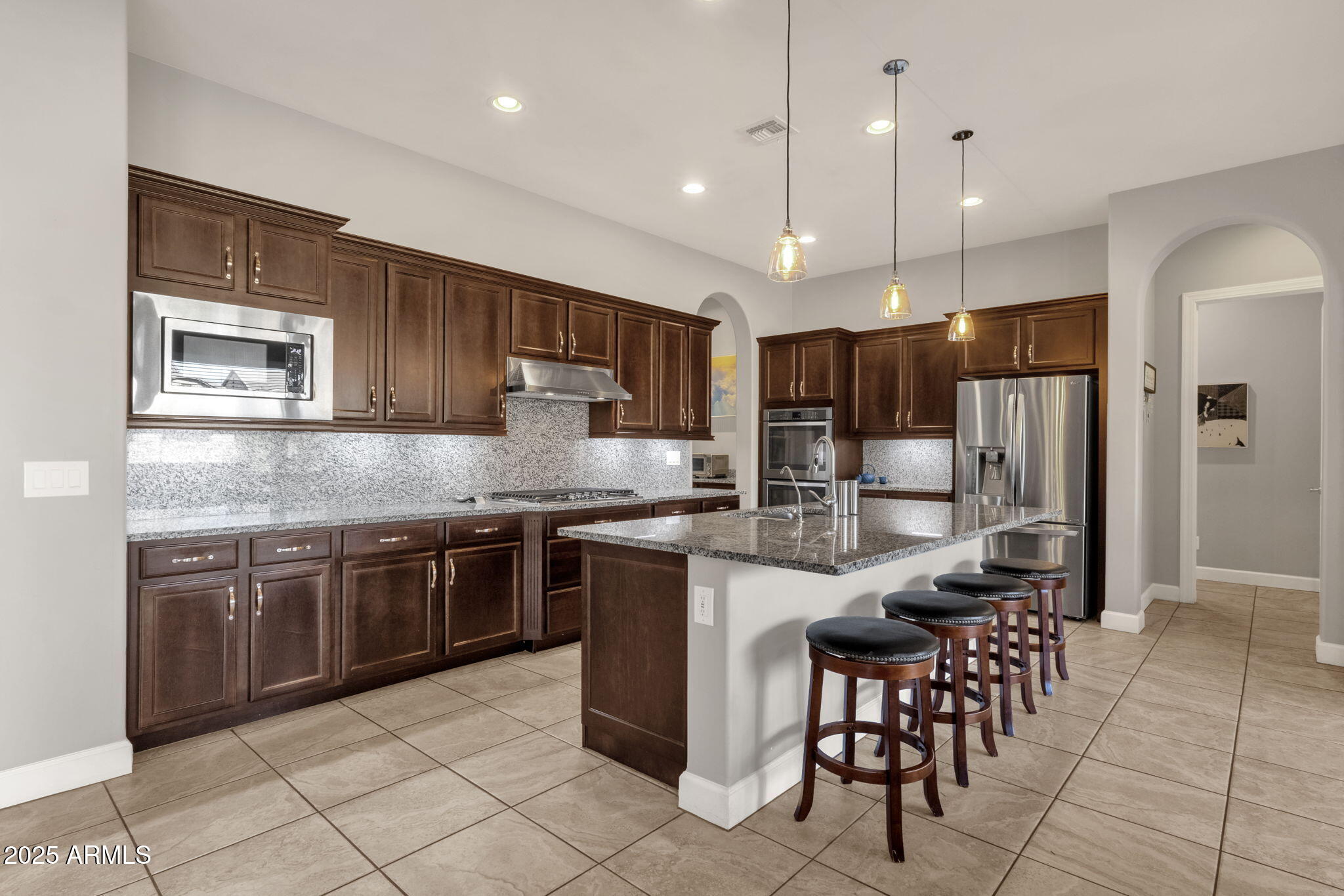 22322 East Rosa Road Queen Creek, AZ 85142 - Photo 8 of 83 a kitchen with stainless steel appliances granite countertop a stove top oven a sink refrigerator and chairs