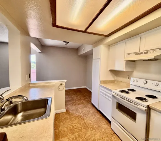 a kitchen with granite countertop a sink and cabinets
