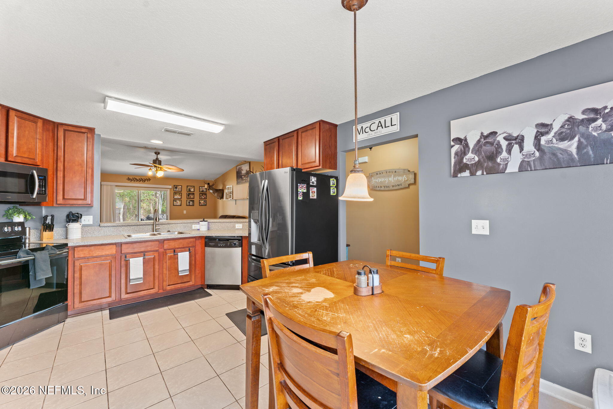 45212 Ingleham Circle Callahan, FL 32011 - Photo 33 of 35 a kitchen with stainless steel appliances wooden floor dining table and chairs