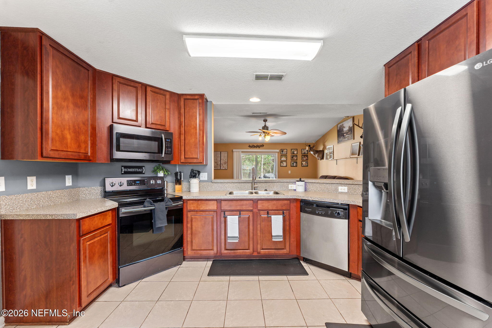 45212 Ingleham Circle Callahan, FL 32011 - Photo 7 of 35 a large kitchen with stainless steel appliances granite countertop a stove top oven a sink and dishwasher