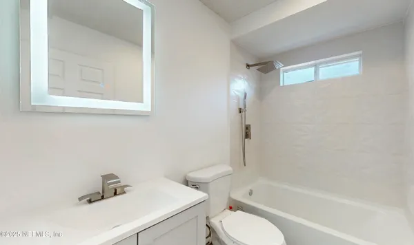 a white toilet sitting next to a bath tub