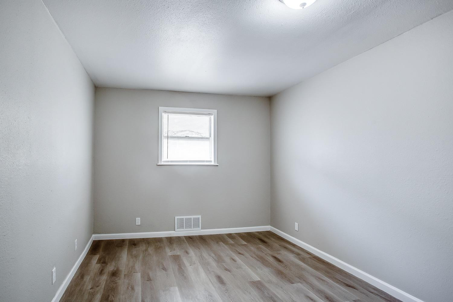 4509 40th Street Lubbock, TX 79414 - Photo 14 of 21 an empty room with wooden floor and windows