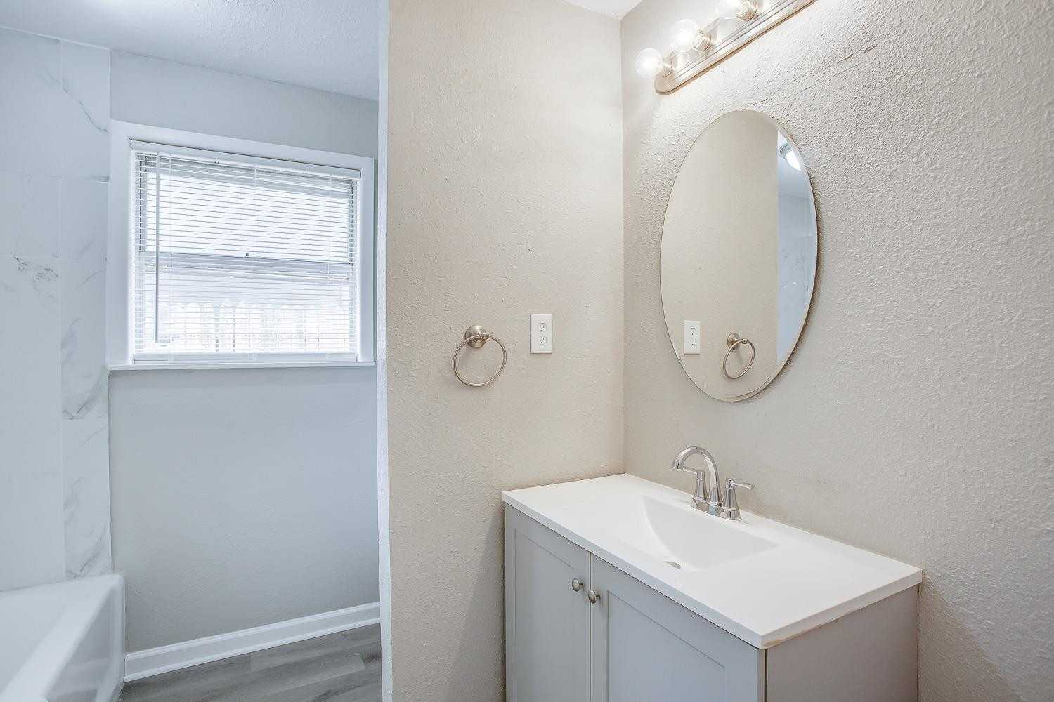 4509 40th Street Lubbock, TX 79414 - Photo 15 of 21 a bathroom with a sink and a mirror