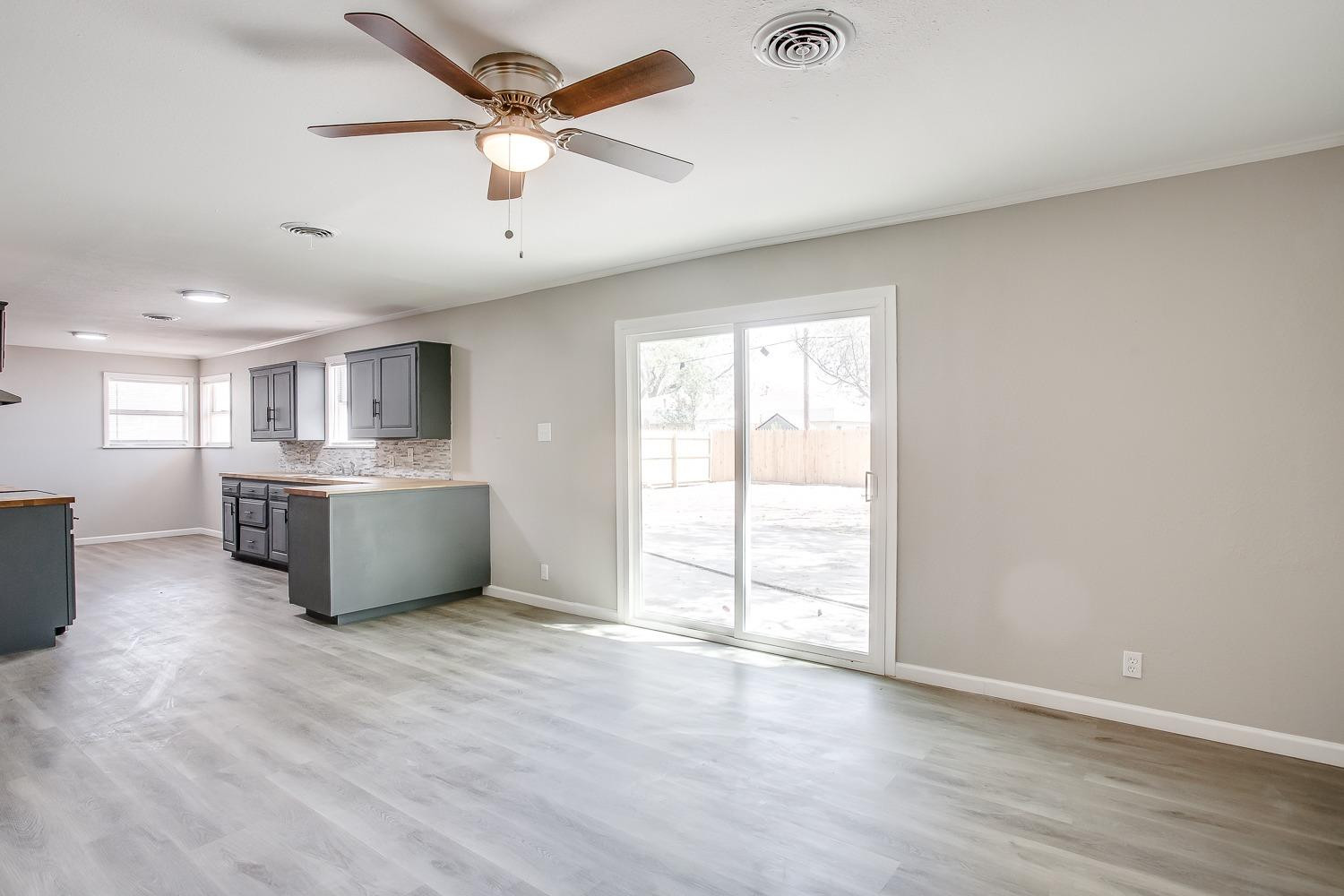 4509 40th Street Lubbock, TX 79414 - Photo 4 of 21 a large white kitchen with a large window a sink and a stove