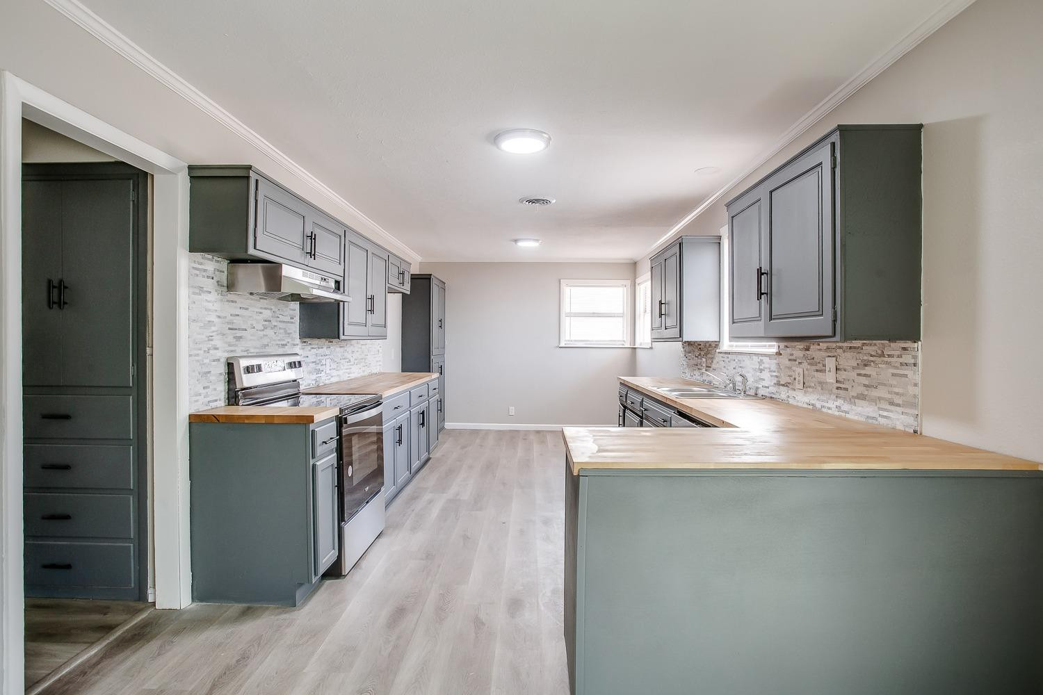 4509 40th Street Lubbock, TX 79414 - Photo 6 of 21 a large kitchen with stainless steel appliances granite countertop a lot of counter space and wooden floors