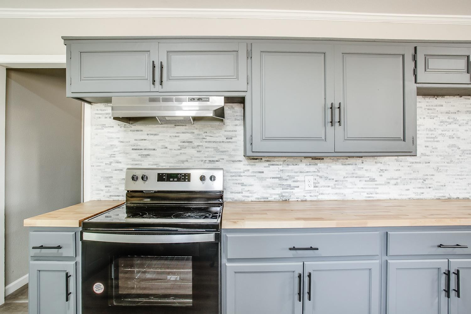 4509 40th Street Lubbock, TX 79414 - Photo 8 of 21 a kitchen with cabinets and a stove top oven