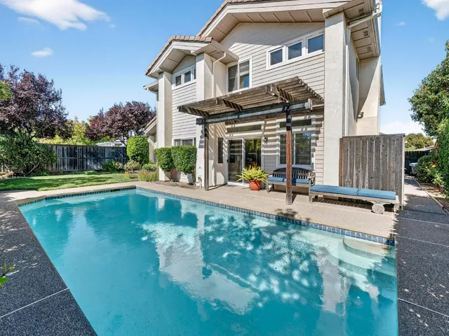 a view of a house with pool and chairs
