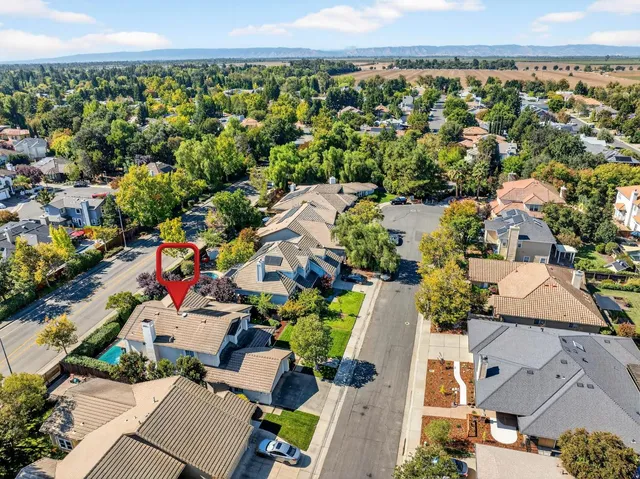 an aerial view of a city with lots of residential buildings and mountain view in back
