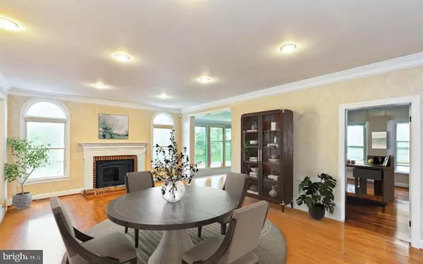 a dining room with furniture wooden floor a fireplace and a chandelier