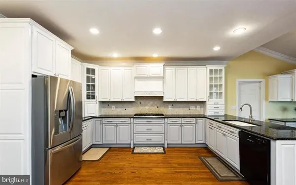 a kitchen with stainless steel appliances granite countertop a refrigerator sink and cabinets