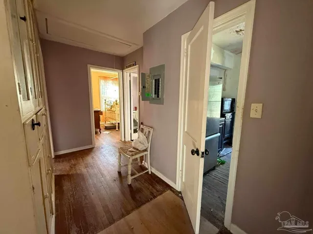 a view of a hallway with furniture and wooden floor