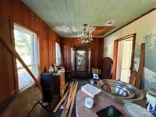 a dining room with furniture a chandelier and window