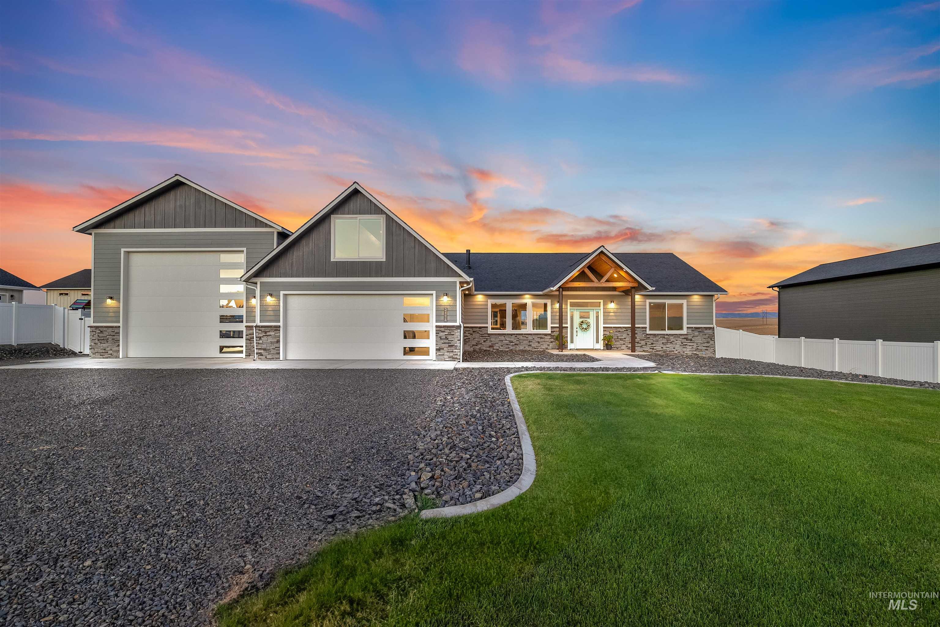 Craftsman inspired home featuring stone siding, a garage, and driveway