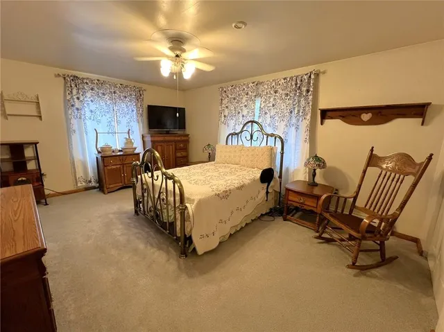 a bedroom with a bed chairs and a flat screen tv