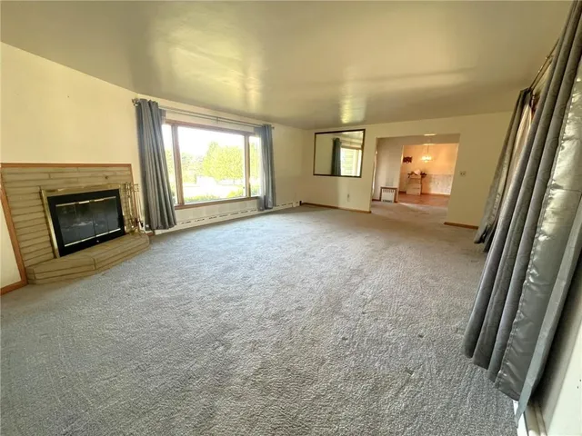 a view of empty room with window and fireplace