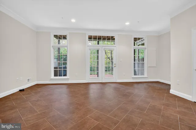 a view of an empty room with wooden floor and a fireplace