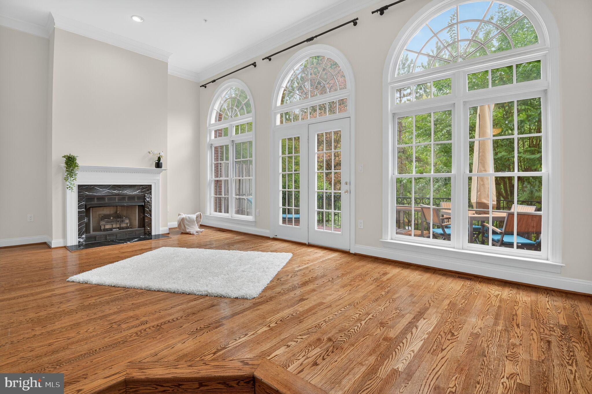 4015 Mansion Drive Northwest Washington, DC 20007 - Photo 5 of 34 a view of an empty room with a fireplace and large windows