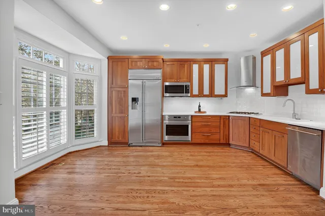 a view of a kitchen with wooden floor and electronic appliances