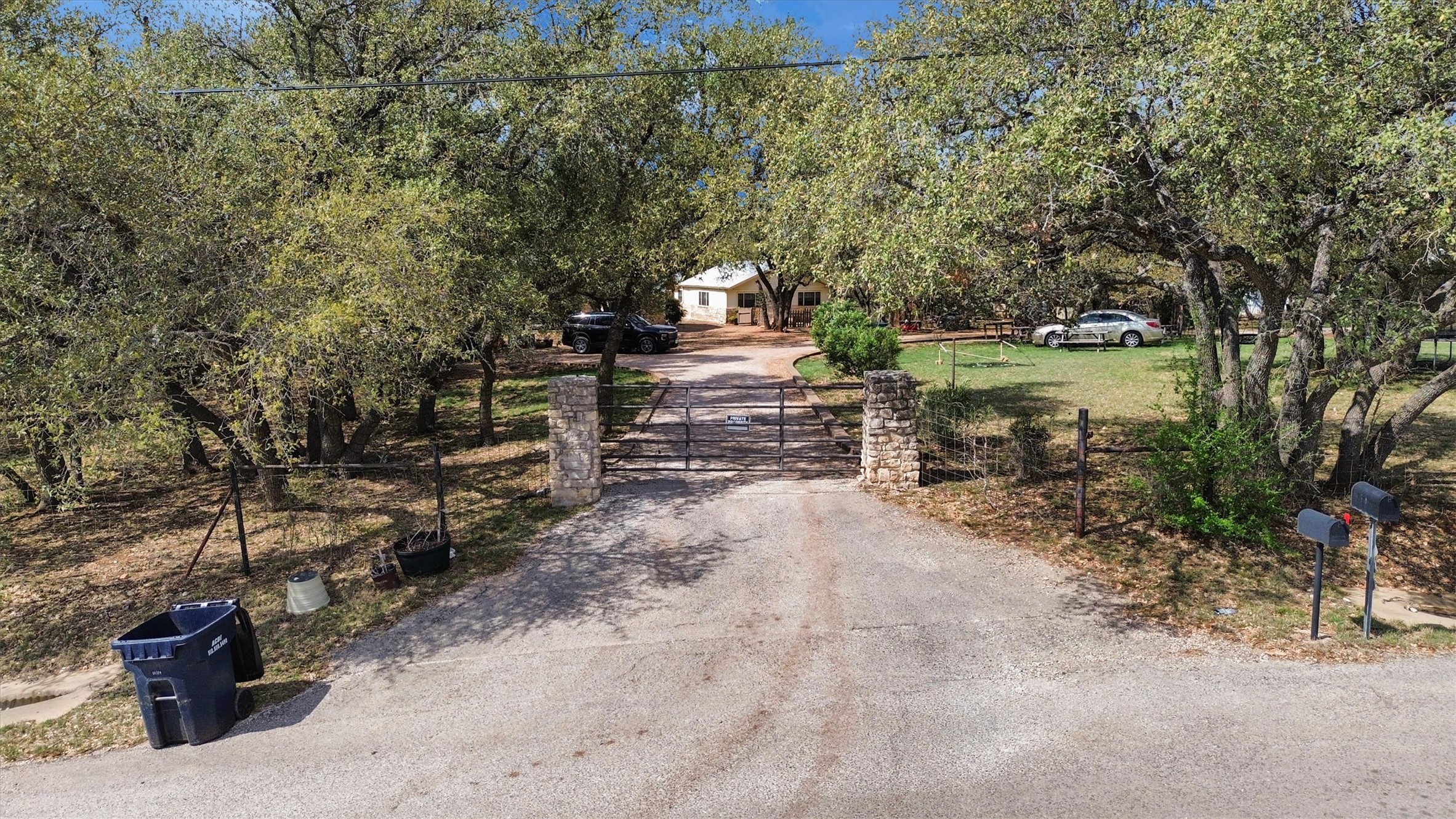 51 County Road 264 Leander, TX 78641 - Photo 17 of 17 View of asphalt driveway featuring a gated entry and a gate