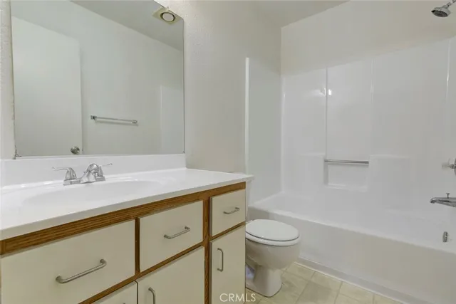 a bathroom with a granite countertop sink a toilet and a bathtub