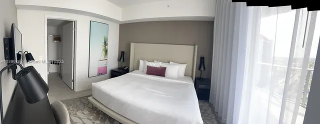 a bedroom with a bed and a large mirror