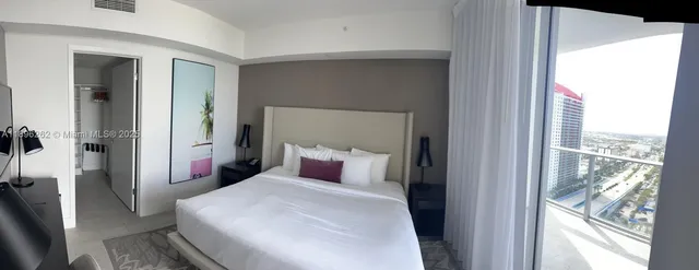 a bedroom with a large bed and a large window