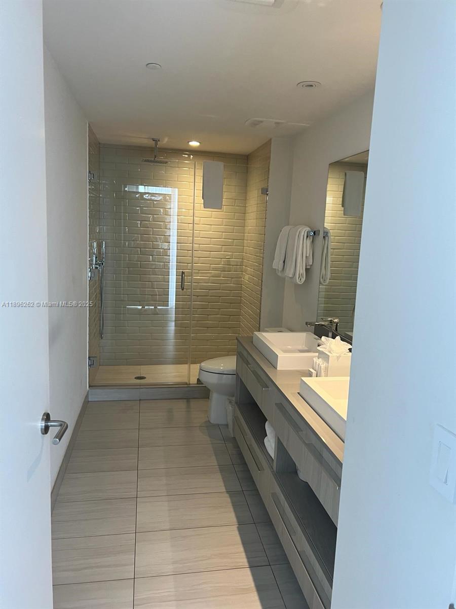 4010 South Ocean Drive, Unit R2004 Hollywood, FL 33019 - Photo 13 of 34 a bathroom with a granite countertop sink a toilet and shower