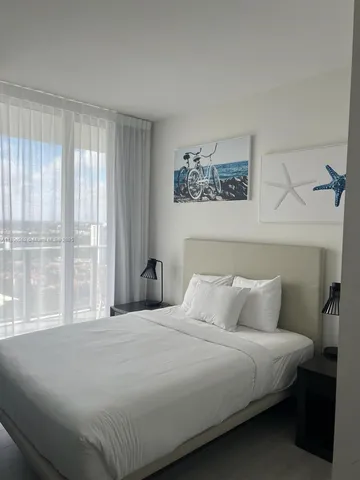 a bedroom with a large bed and a window