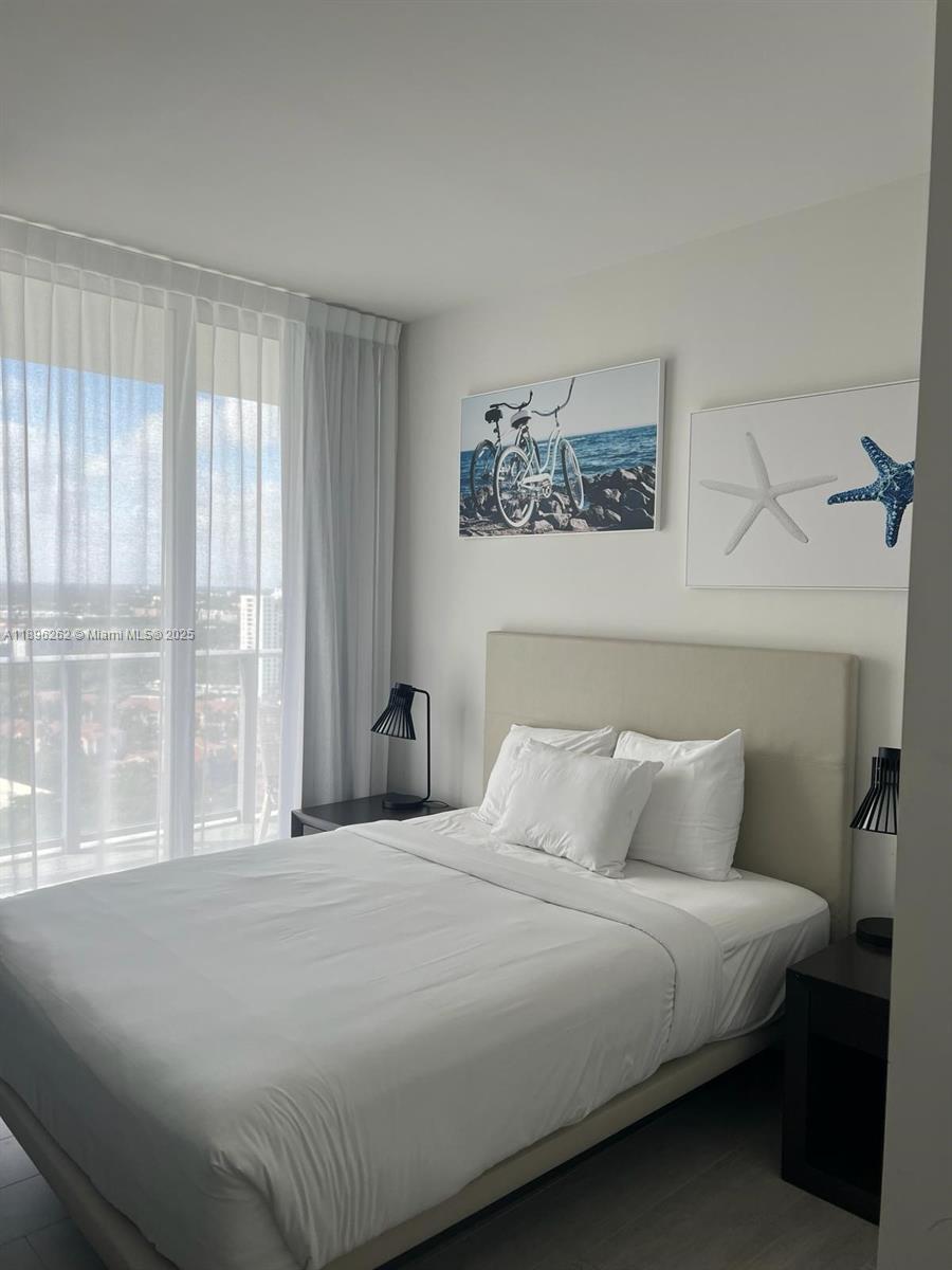 4010 South Ocean Drive, Unit R2004 Hollywood, FL 33019 - Photo 2 of 34 a bedroom with a large bed and a window