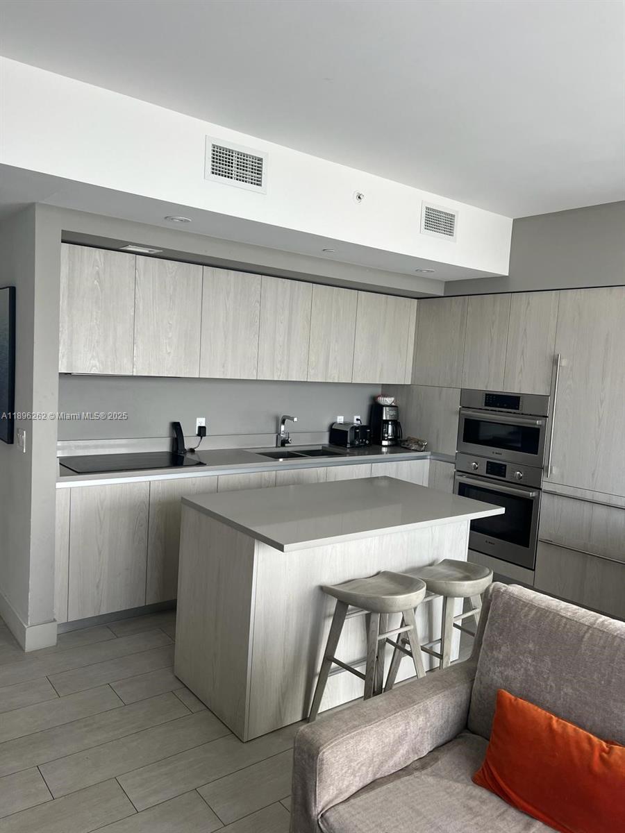 4010 South Ocean Drive, Unit R2004 Hollywood, FL 33019 - Photo 21 of 34 a kitchen with stainless steel appliances granite countertop a sink and a stove