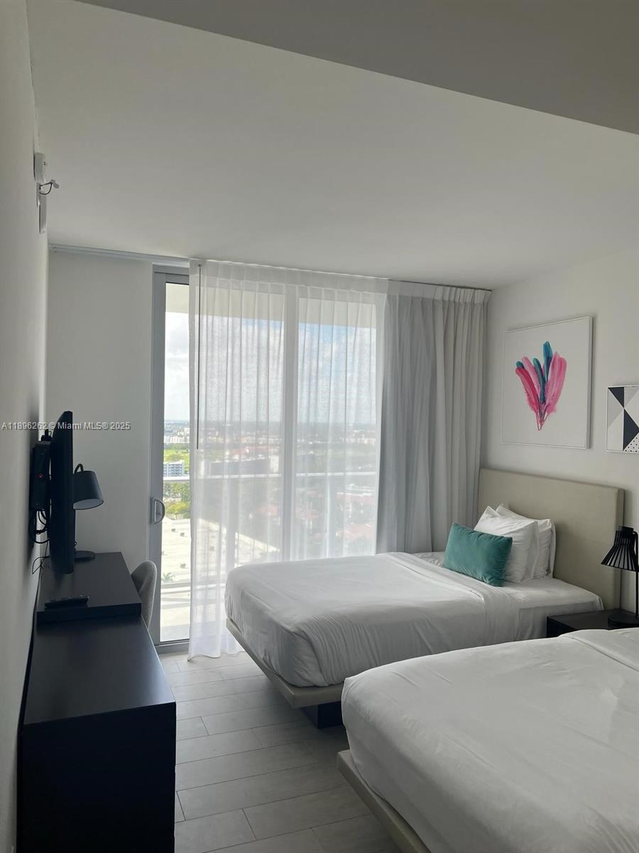 4010 South Ocean Drive, Unit R2004 Hollywood, FL 33019 - Photo 6 of 34 a bedroom with two beds and a large window