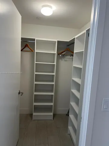 a view of walk in closet with empty racks