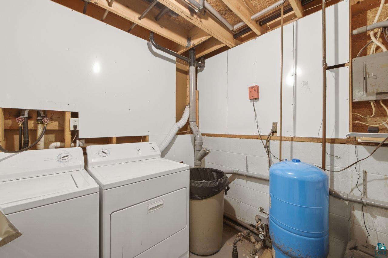 61018 Dahlstrom Road Ashland, WI 54806 - Photo 16 of 28 Dedicated utility space featuring laundry hookups, exposed wooden ceiling joists, and visible plumbing infrastructure