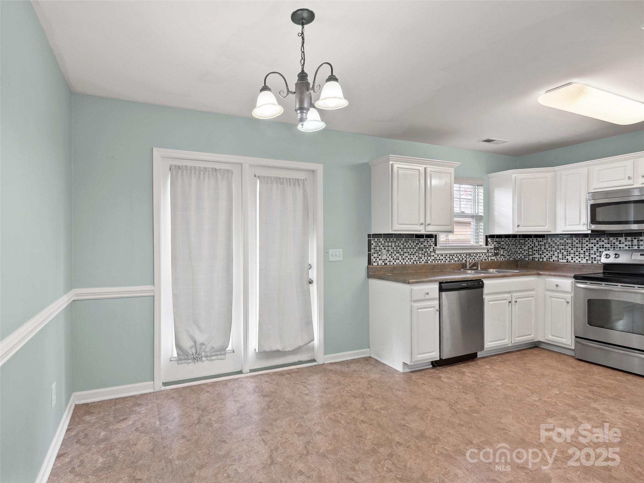 24 Torrington Avenue Fletcher, NC 28732 - Photo 7 of 32 a kitchen with granite countertop white cabinets and stainless steel appliances