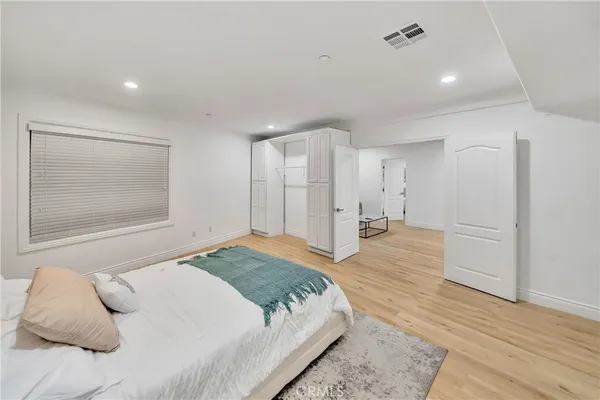 a view of an empty room with kitchen and window