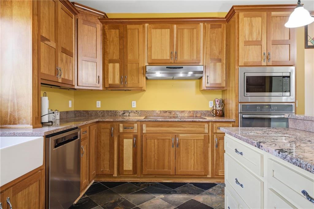 6729 Big Texas Valley Road Northwest Rome, GA 30165 - Photo 21 of 95 a kitchen with stainless steel appliances granite countertop a stove a sink and a microwave