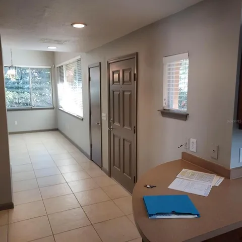 en empty room with windows and chandelier