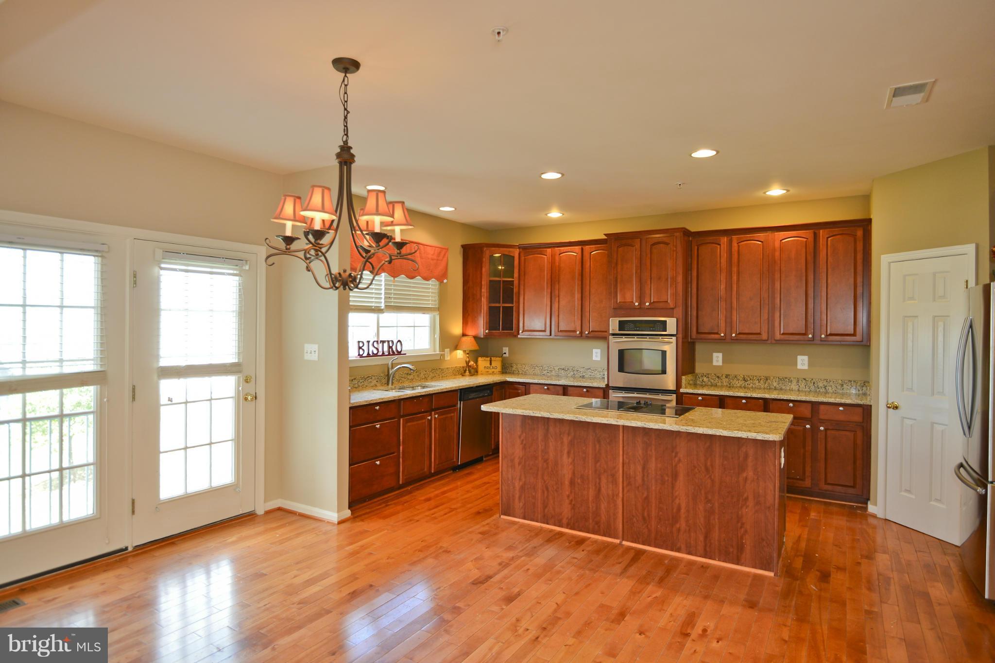 14618 Bubbling Spring Road Boyds, MD 20841 - Photo 7 of 26 a kitchen with stainless steel appliances granite countertop a stove top oven a sink dishwasher and a refrigerator with wooden floor