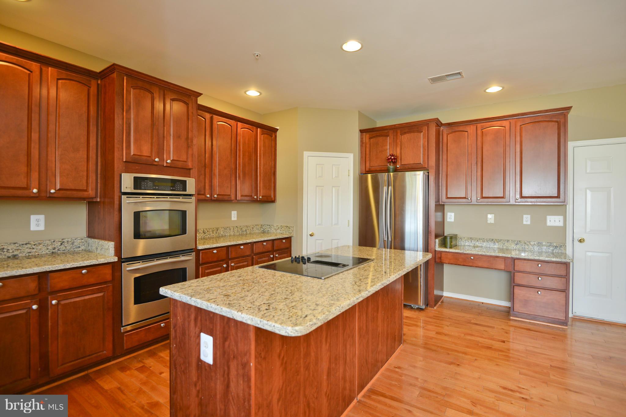 14618 Bubbling Spring Road Boyds, MD 20841 - Photo 8 of 26 a kitchen with stainless steel appliances granite countertop a refrigerator a sink dishwasher a stove with wooden cabinets and floor