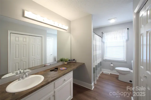 a bathroom with a sink double vanity granite and a toilet