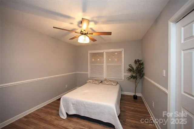 a spacious bedroom with a bed and a chandelier
