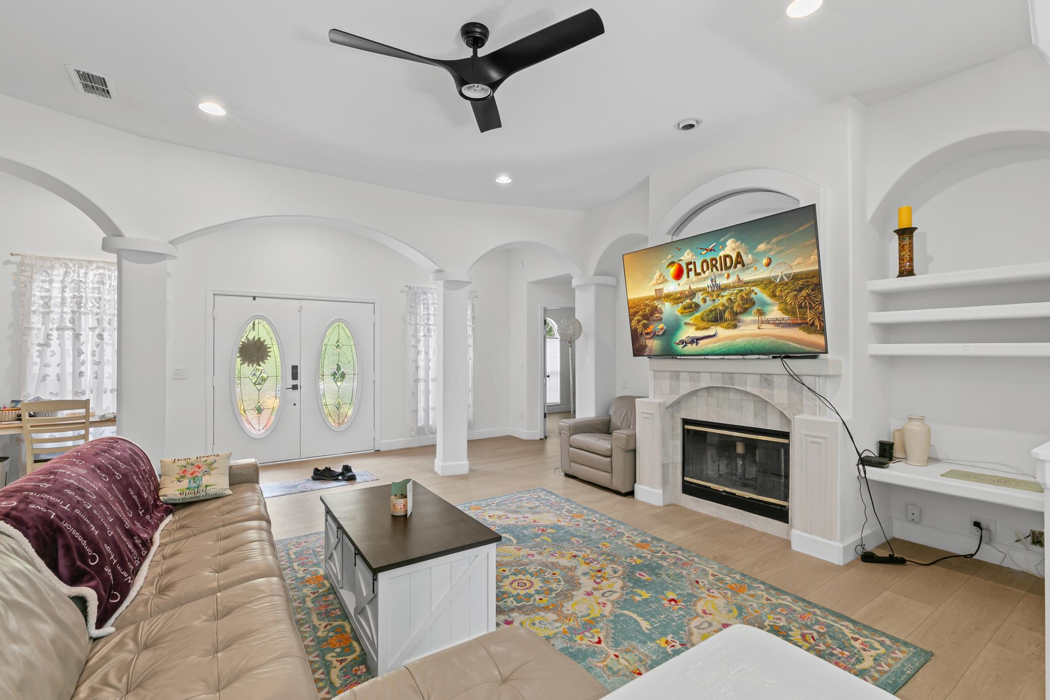 11511 Mandarin Road Jacksonville, FL 32223 - Photo 2 of 41 Living area featuring french doors, built in features, a fireplace, light wood finished floors, and arched walkways