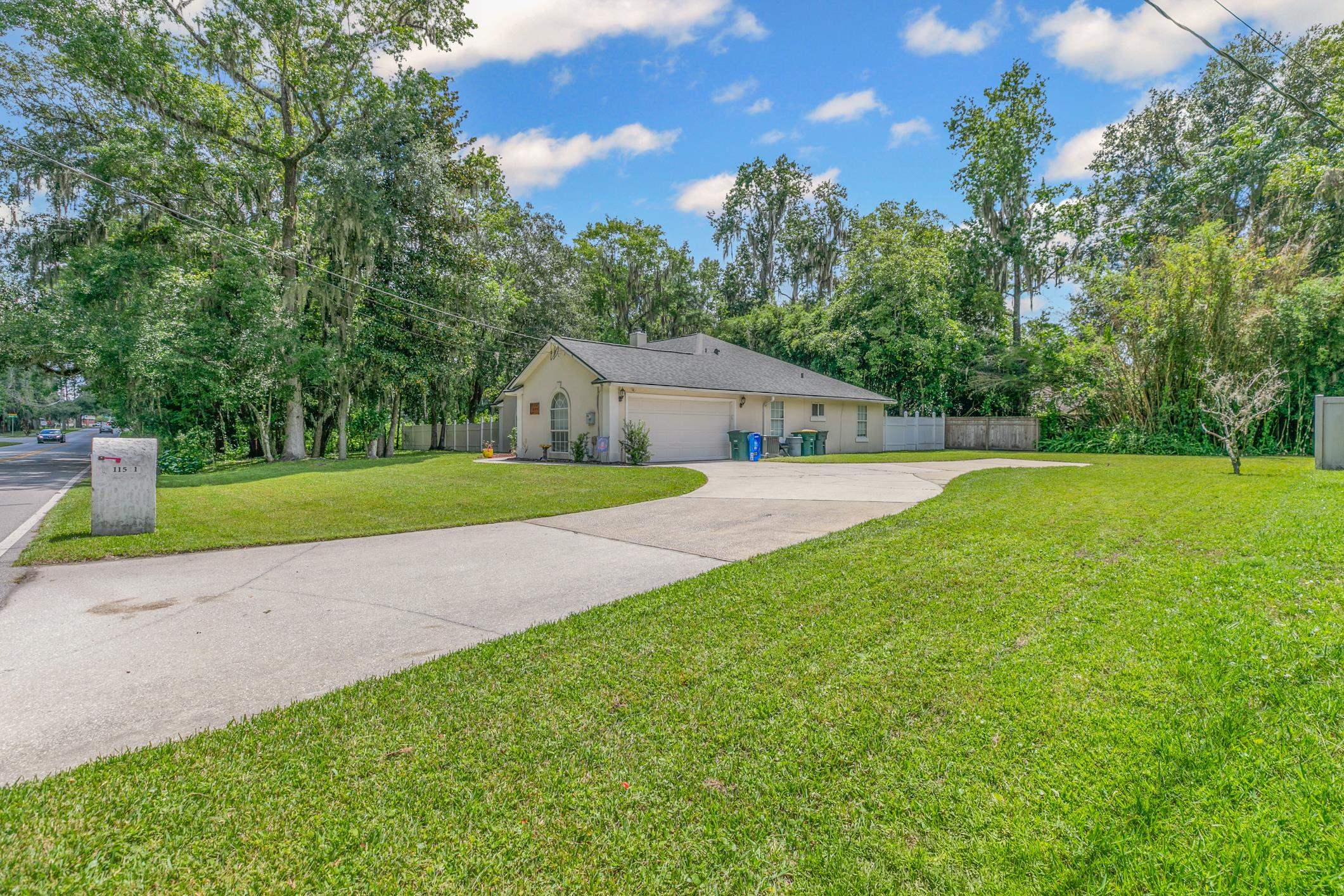 11511 Mandarin Road Jacksonville, FL 32223 - Photo 28 of 41 View of front of property featuring concrete driveway, a garage, and view of scattered trees