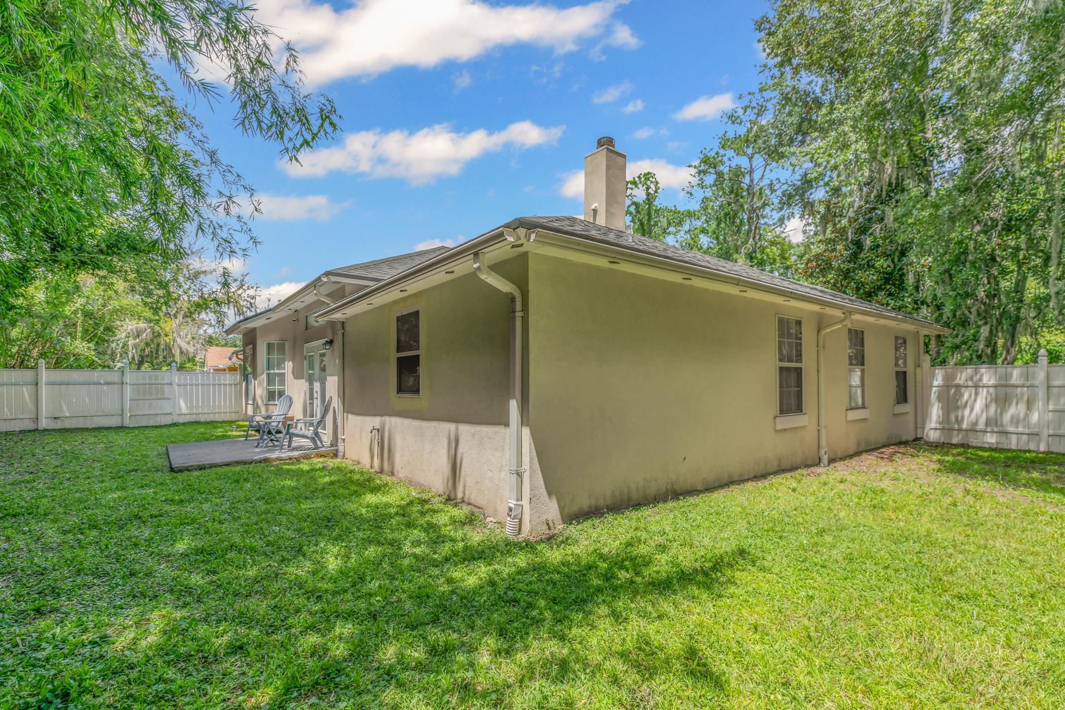 11511 Mandarin Road Jacksonville, FL 32223 - Photo 35 of 41 Back of house featuring a fenced backyard, a chimney, and stucco siding