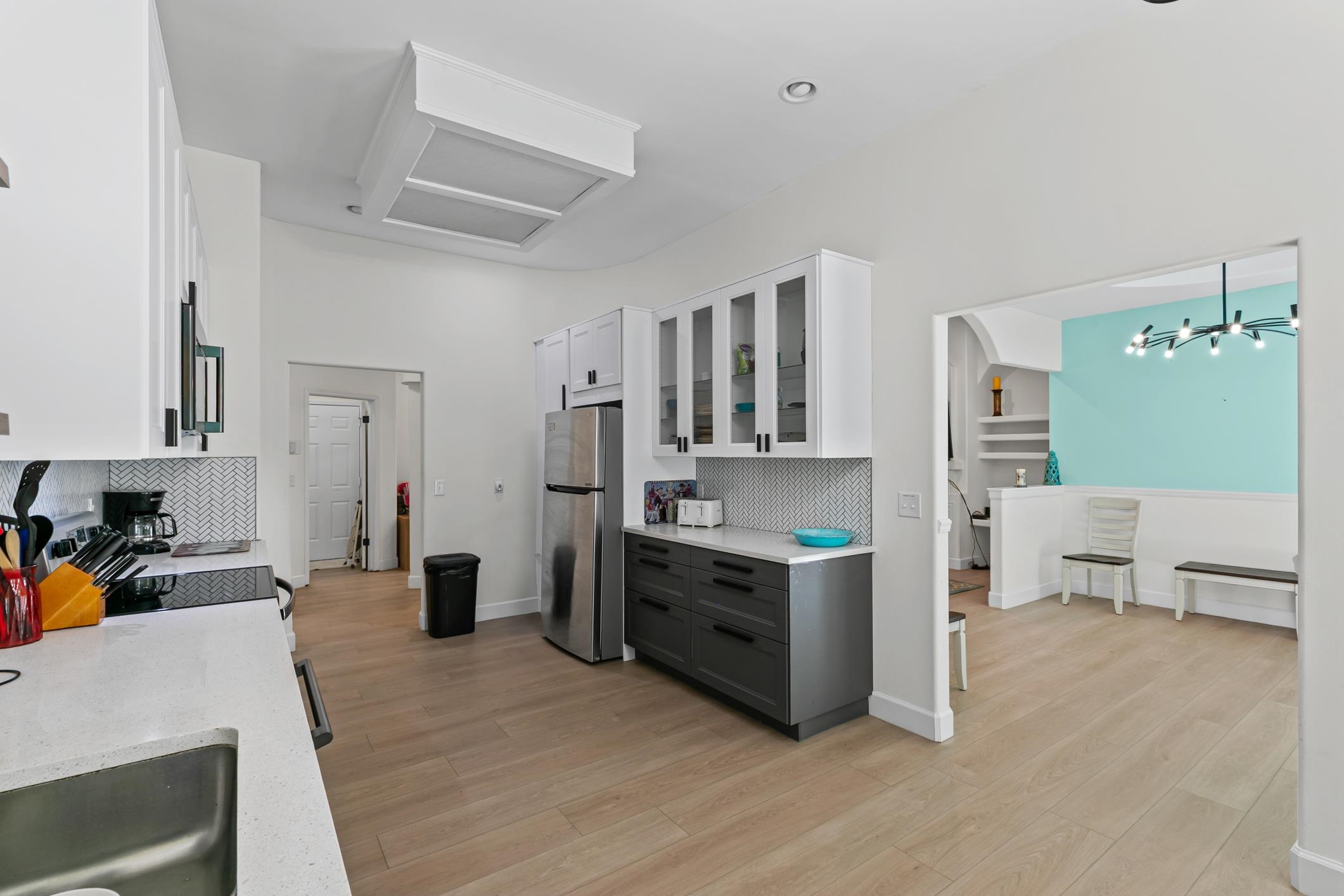 11511 Mandarin Road Jacksonville, FL 32223 - Photo 9 of 41 Kitchen with decorative backsplash, glass insert cabinets, gray cabinets, white cabinets, and light wood-type flooring